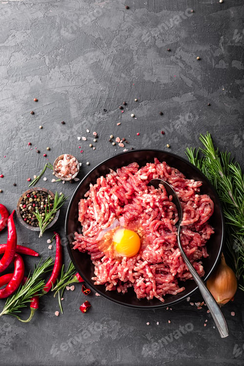 Preview: Mince. Ground meat with ingredients for cooking on black background. Top view