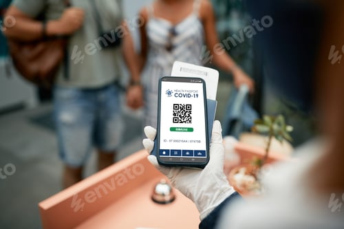 Preview: Close-up of receptionist checking health passports of vaccinated guests during coronavirus pandemic.