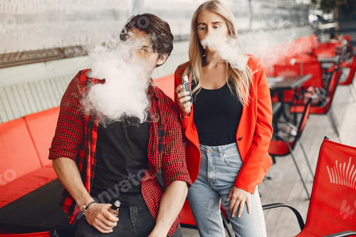 Preview: Stylish young couple with vape in a city