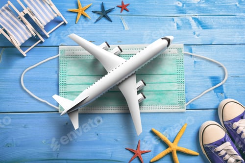 Preview: Plane model and coronavirus protective face medical mask on blue wood. 3d illustration
