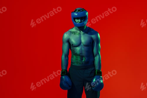 Preview: Portrait of man wearing head guard and boxing gloves practicing for fight on studio background