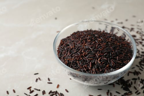 Preview: Uncooked brown rice in glass bowl on table