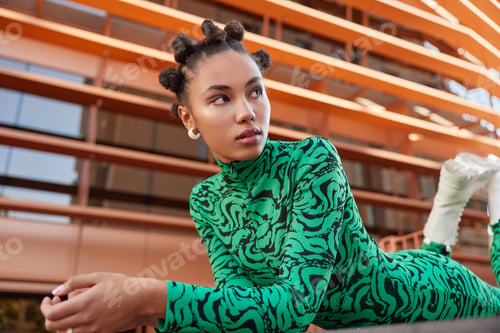 Preview: Horizontal shot of dreamy thoughtful woman with makeup concentrated aside wears green costume has fu