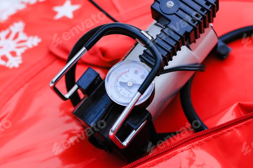 Preview: Electric pump with monometer pumping air into tire of tube on winter day. Equipment, device.