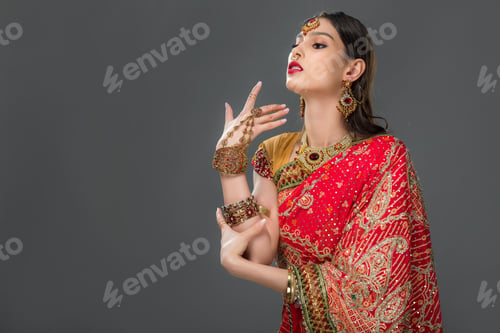 Preview: attractive indian woman gesturing in traditional sari and accessories, isolated on grey