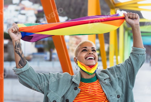 Preview: Young smiling woman holding rainbow flag symbol of Lgbtq social movement