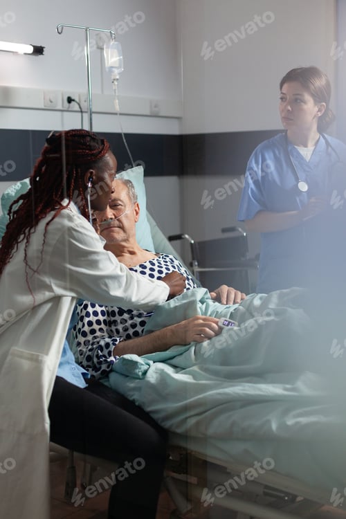 Preview: Cardiologist in uniform examining senior man during medical visit