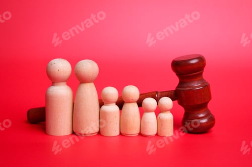 Preview: Judge gavel with many wooden figures of family members close-up