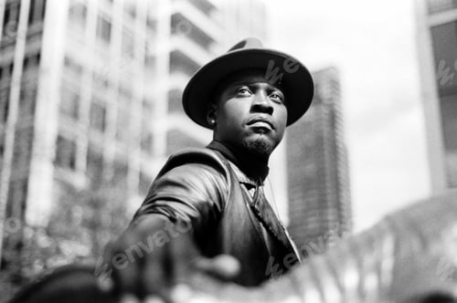Preview: Majestic chromatic portrait of black man looking away in the street.