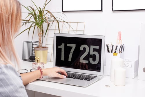 Preview: Beautiful young woman working on laptop computer while sitting at home table