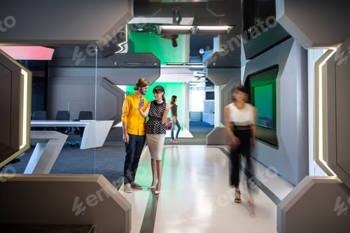 Preview: Business people discussing on a busy office corridor