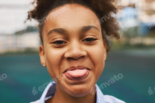Preview: Attractive youthful African American girl showing her tongue