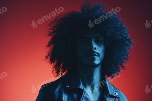 Preview: Portrait of fashion man with curly hair on red background multinational, colored light, black