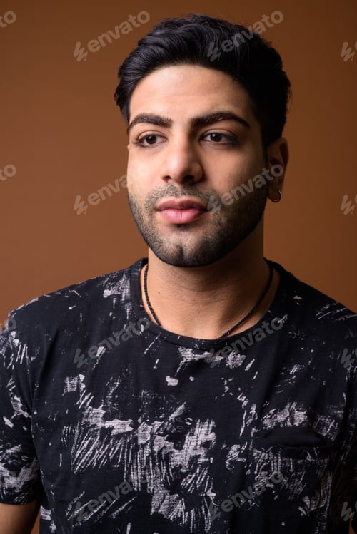 Preview: Young handsome Indian man against brown background