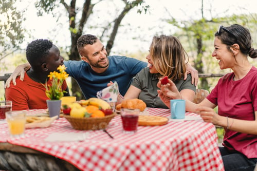 Preview: Group of cheerful multiethnic friends meets at brunch table