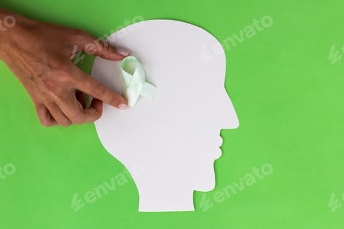 Preview: Brain paper cutout with green ribbon on green background with copy space. Mockup for world mental