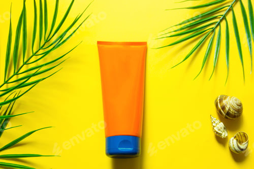 Preview: Tube of sunscreen on a yellow summer background with palm leaves and the sun