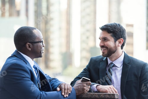 Preview: Two businessmen talking outdoors