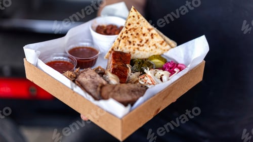 Preview: Cook holding dish with meal. Meat and toppings. BBQ. Street Food