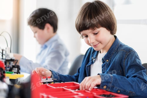 Preview: Cheerful Interested Smiling Child Making Toy