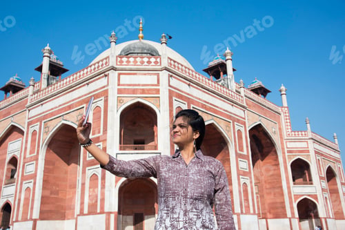 Preview: Indian woman taking selfie with smartphone in front of Humayun's Tomb