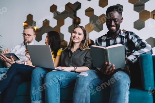 Preview: Diverse people sitting on sofa in living room