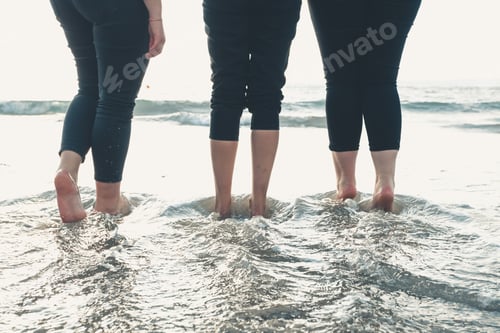 Preview: Close up of three women legs on the beach during a sunny day, vacation and relax concept