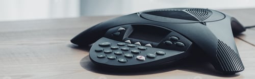 Preview: close-up shot of conference phone on wooden table at office