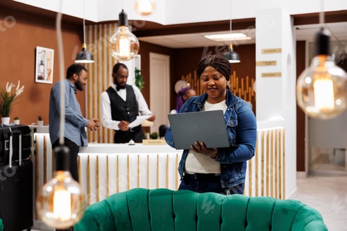 Preview: Woman with laptop at hotel lounge area