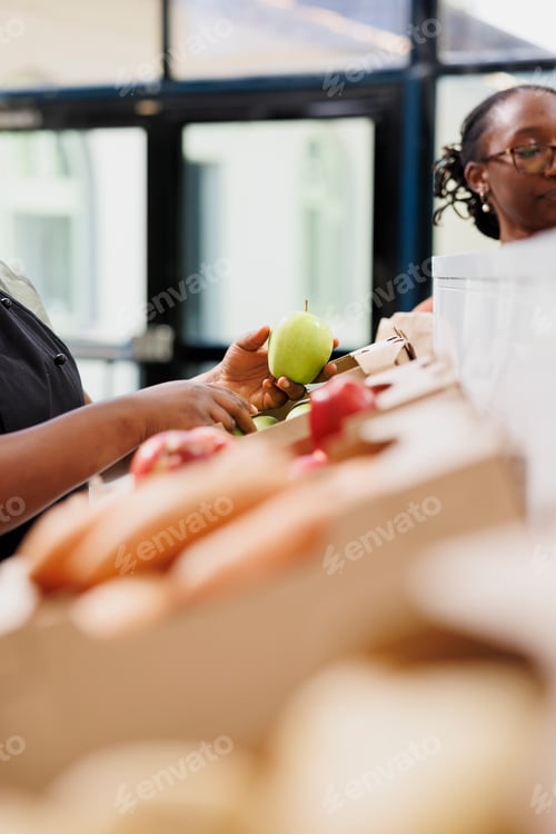 Preview: Shopkeeper arranging bio apples in boxes