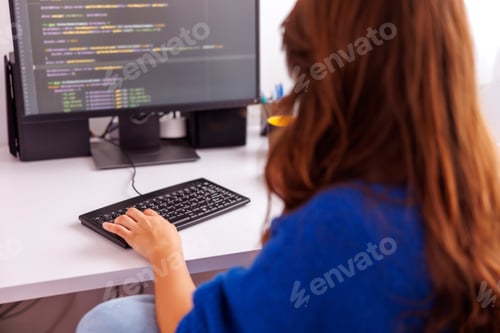 Preview: Female programmer coding while working remotely from home
