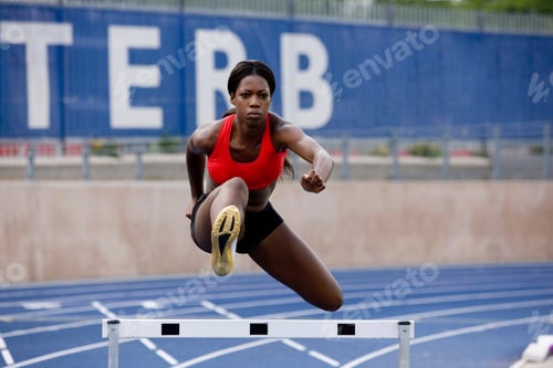 Preview: Runner jumping over hurdles on track