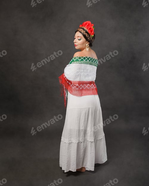 Preview: Mexican woman with white dress and scarf with the colors of the Mexican flag..