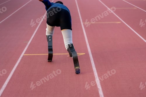 Preview: Asian para-athletes with prosthetic blades sprint on a running track at stadium.