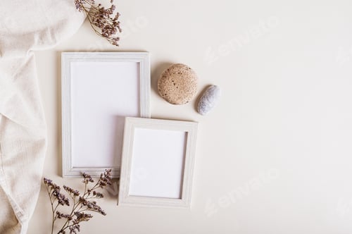 Preview: A pair of empty photo frames, dried flowers and a stone on a light background