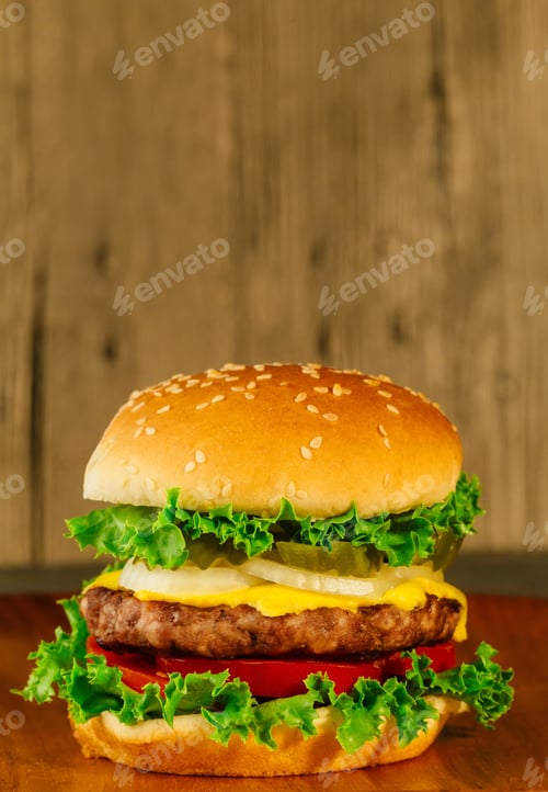 Preview: Classic deluxe cheeseburger with lettuce, onions, tomato and pickles on a sesame seed bun