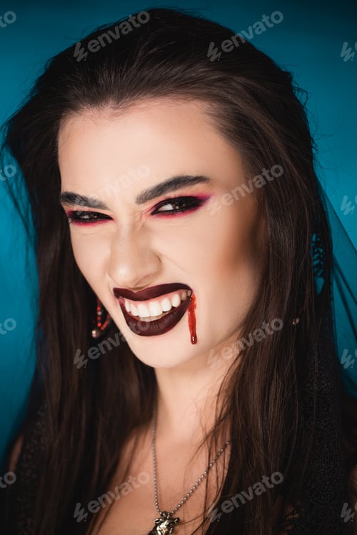 Preview: creepy woman with blood on face showing white teeth on blue