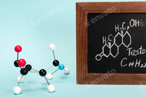 Preview: Hormone construction near blackboard with formula of testosterone on blue background