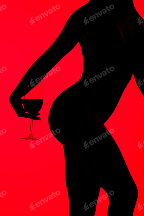Preview: cropped view of black silhouette of seductive girl holding glass of wine isolated on red