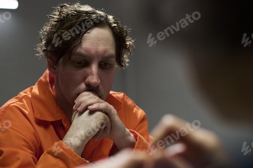Preview: Contemplating Person in Orange Prison Uniform