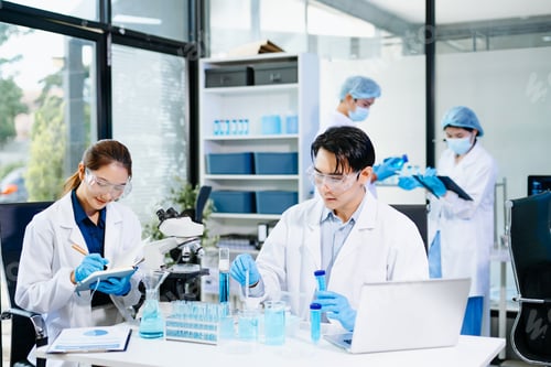 Preview: cientists working together in a modern lab with microscopes and blue liquids, symbolizing chemistry,