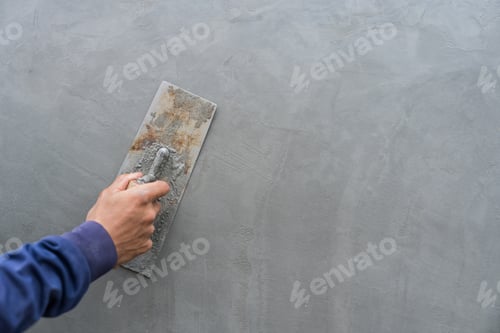 Preview: Hand plasterer plastering gray cement wall background, hand worker brush rough for smooth wall