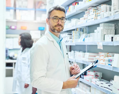 Preview: Shot of a mature man doing inventory in a pharmacy with his colleague in the background