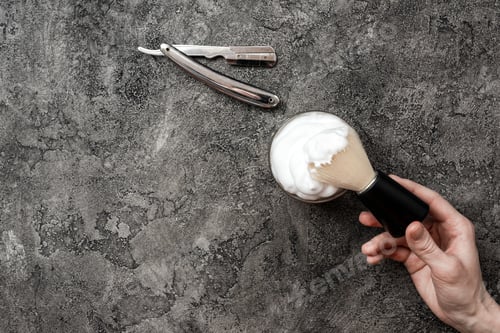 Preview: Shaving accessories on gray, plaster background. Tools. Disposable shaving razor, brush, cream.
