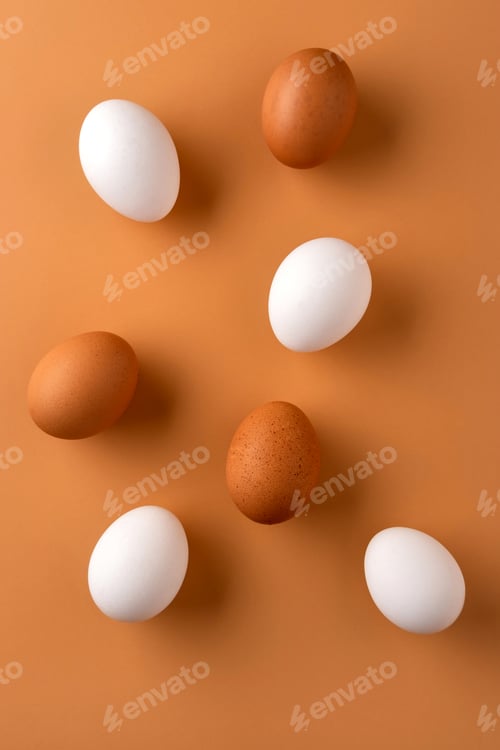 Preview: Brown and white chicken egges on beige background. Chicken eggs on the table.