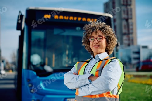 Preview: Happy female bus driver with crossed arms looking at camera.