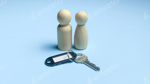 Preview: Two Wooden Figures with House Key and Tag Representing New Home Owners and Property Access