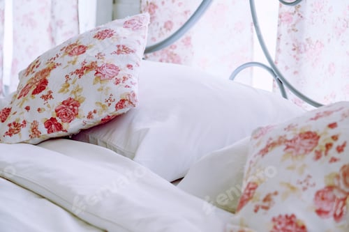 Preview: Bright bedroom interior with flower pattern pillows on bed