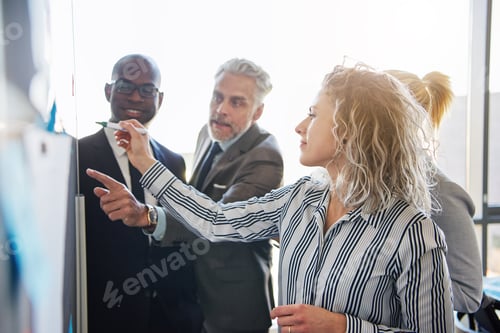 Preview: Corporate colleagues strategizing together on a whiteboard in an office
