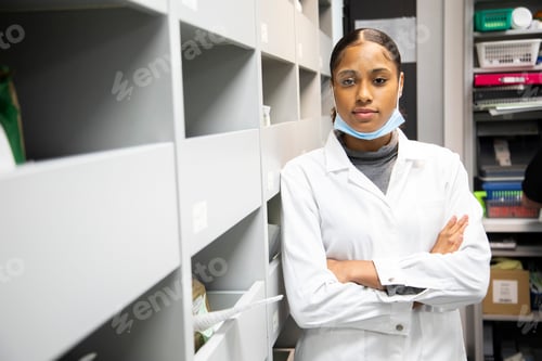 Preview: Confident healthcare professional in a lab coat standing with arms crossed.